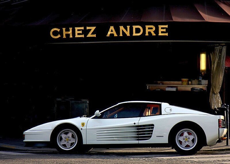 White Ferrari parked outside a restaurant