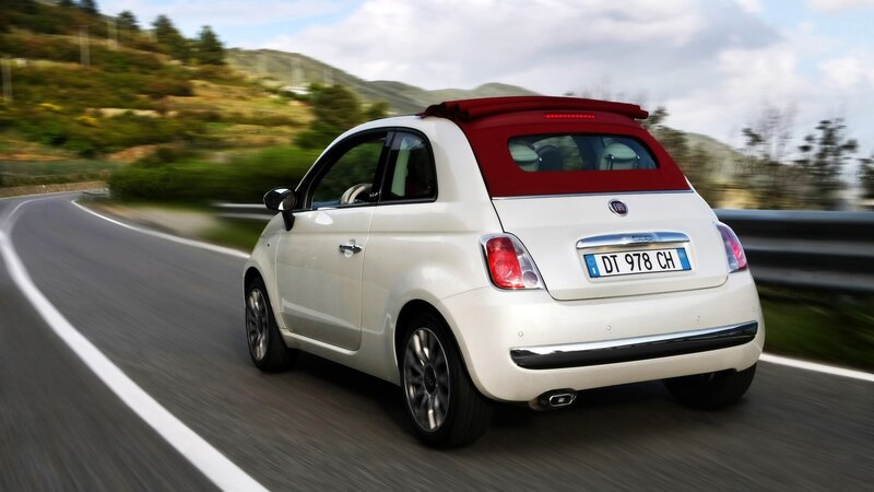 White Fiat 500 driving on road