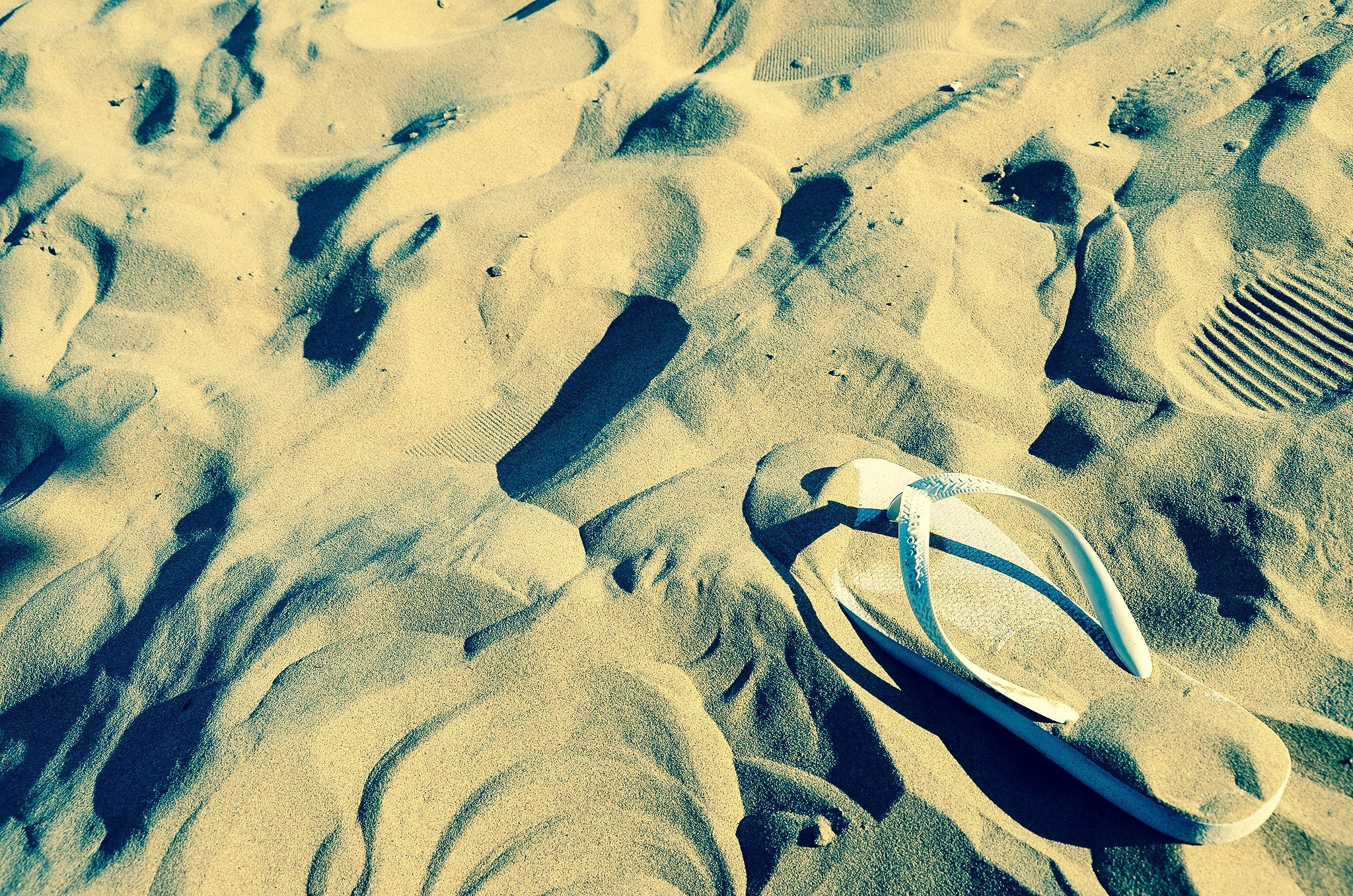 white flip-flop on sandy beach