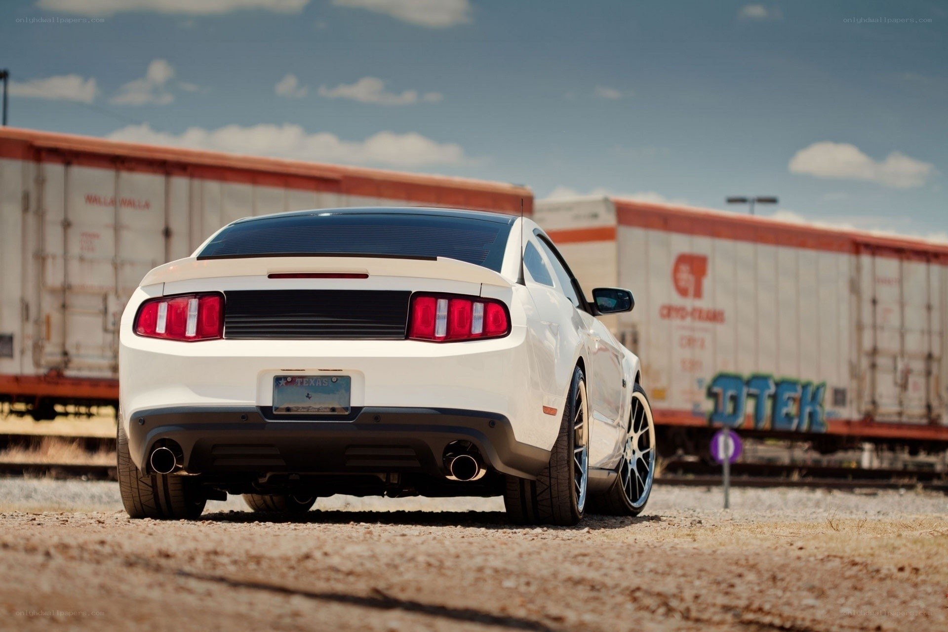 White Ford Mustang near train