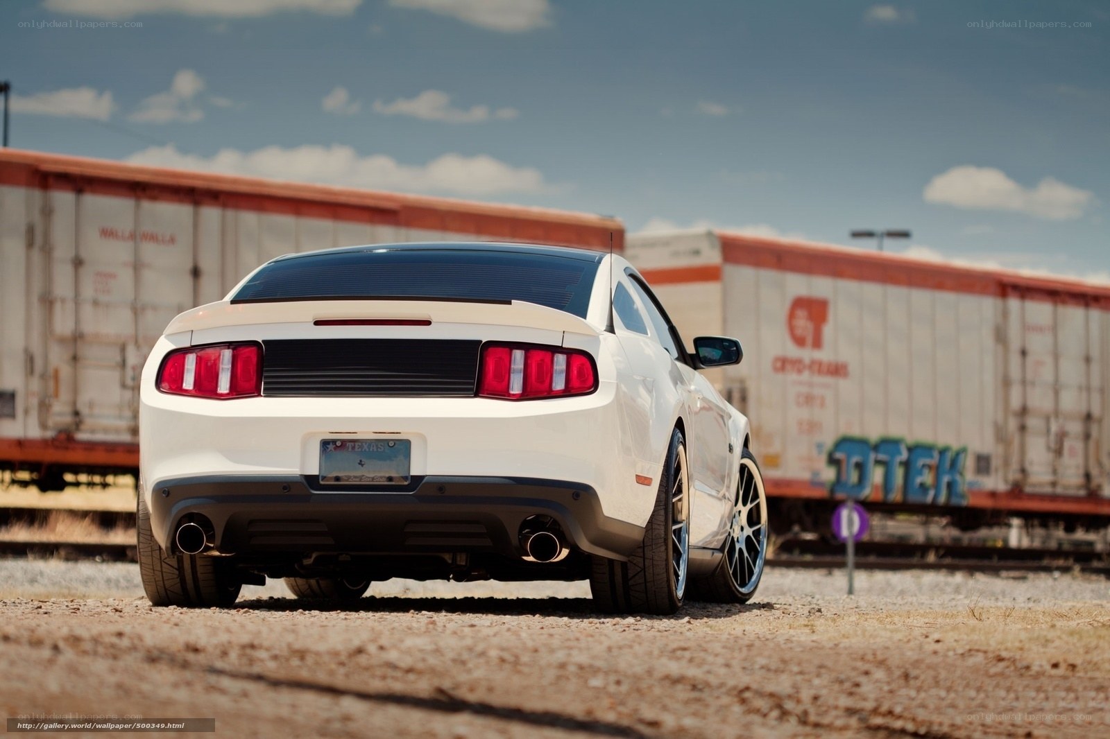 White Ford Mustang near train