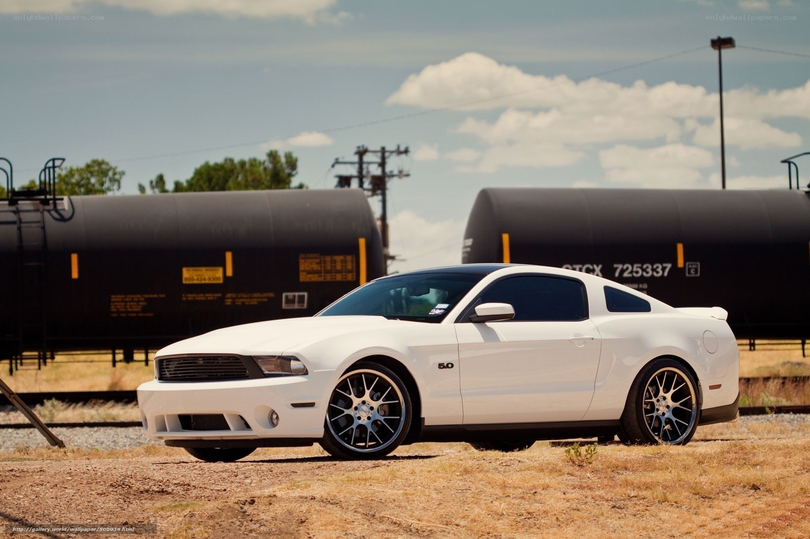 White Ford Mustang on train tracks