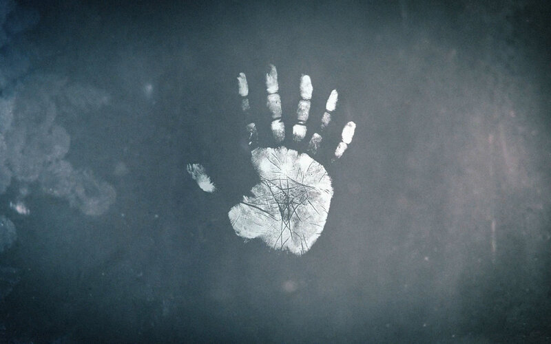 White Handprint on Dark Surface — Gray