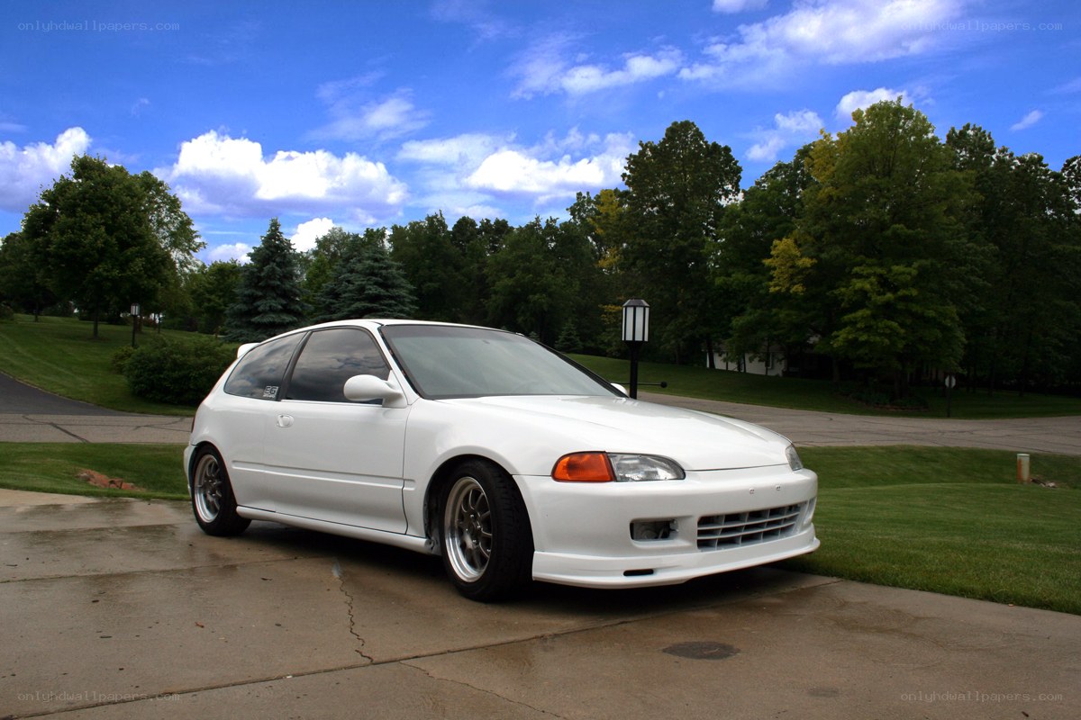 white hatchback car on driveway