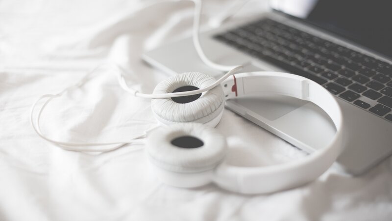 White Headphones on Bed