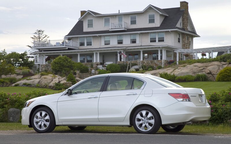 White Honda Accord by a coastal home