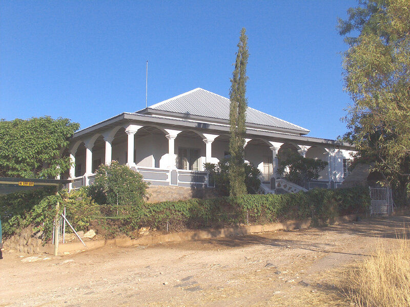 White house with porch and greenery