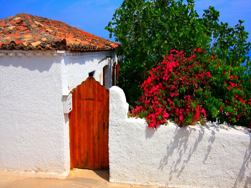 White house with red roof and flowers