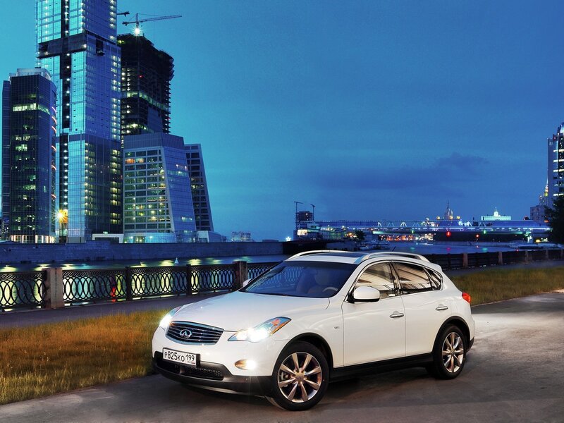 White Infiniti in city at dusk