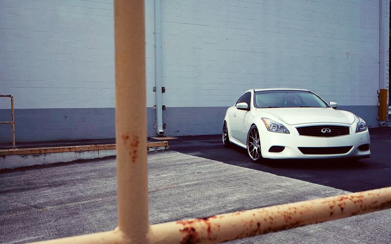 White Infiniti parked in lot