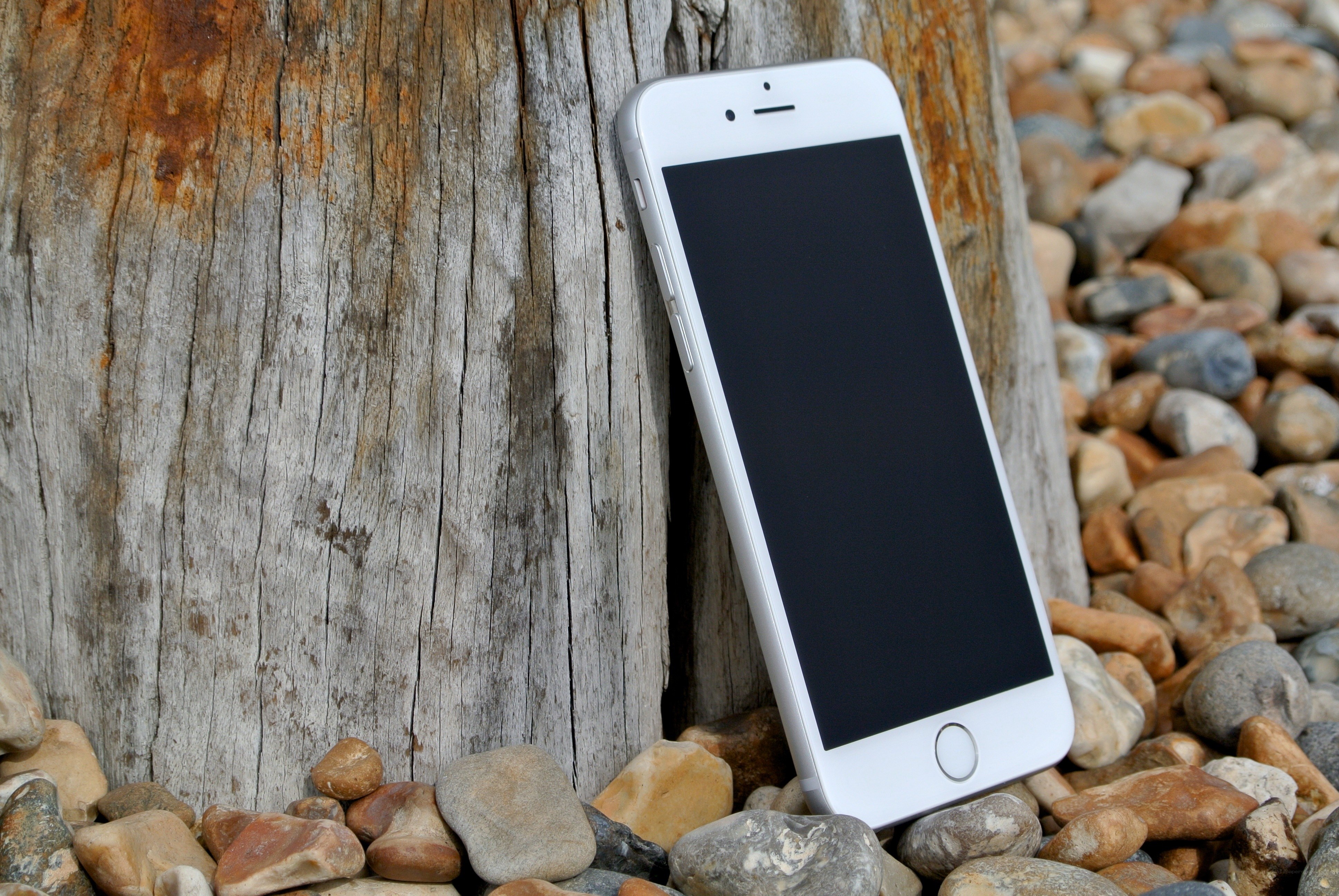 White iPhone on pebbles