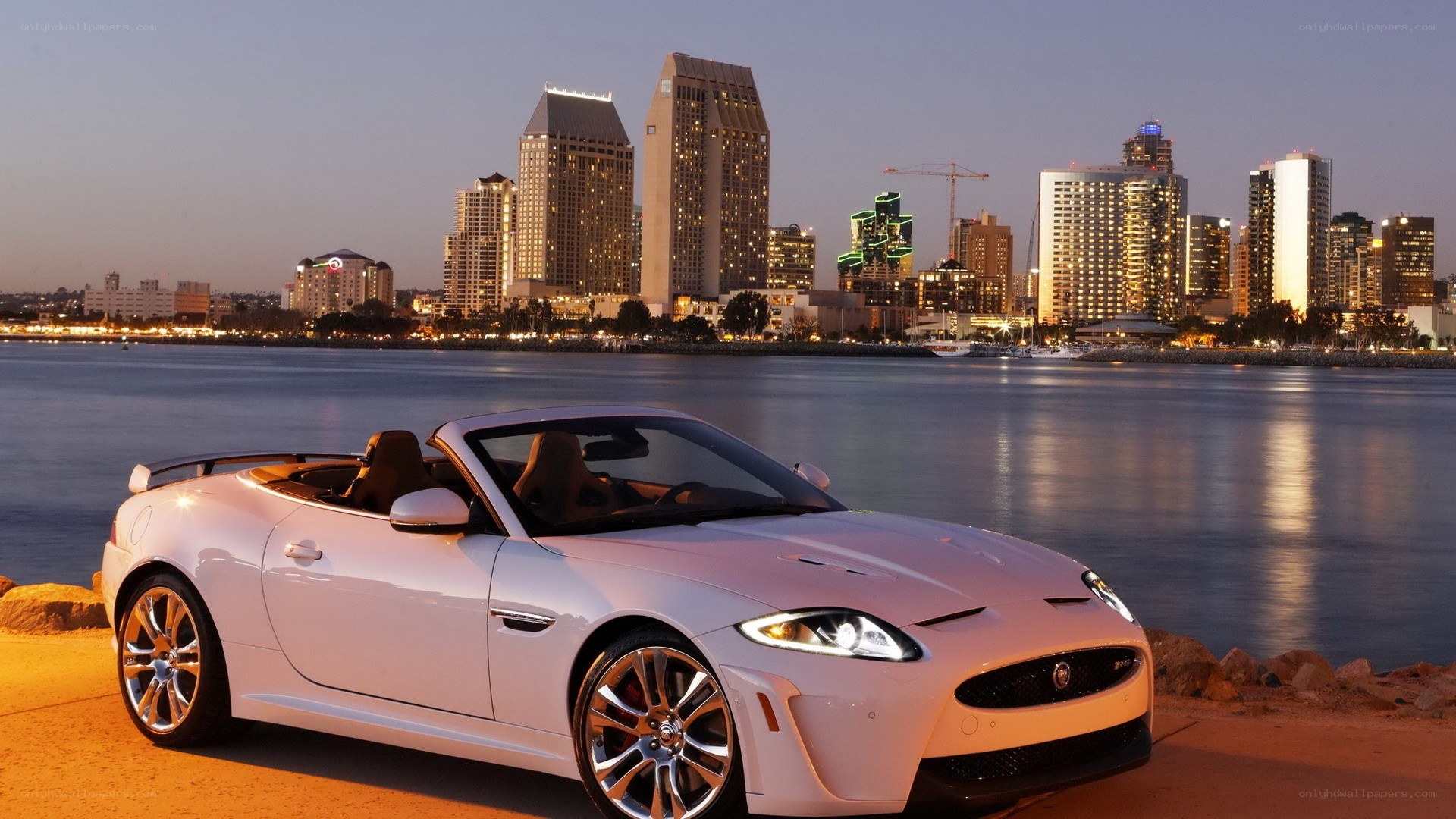 White Jaguar convertible by the water