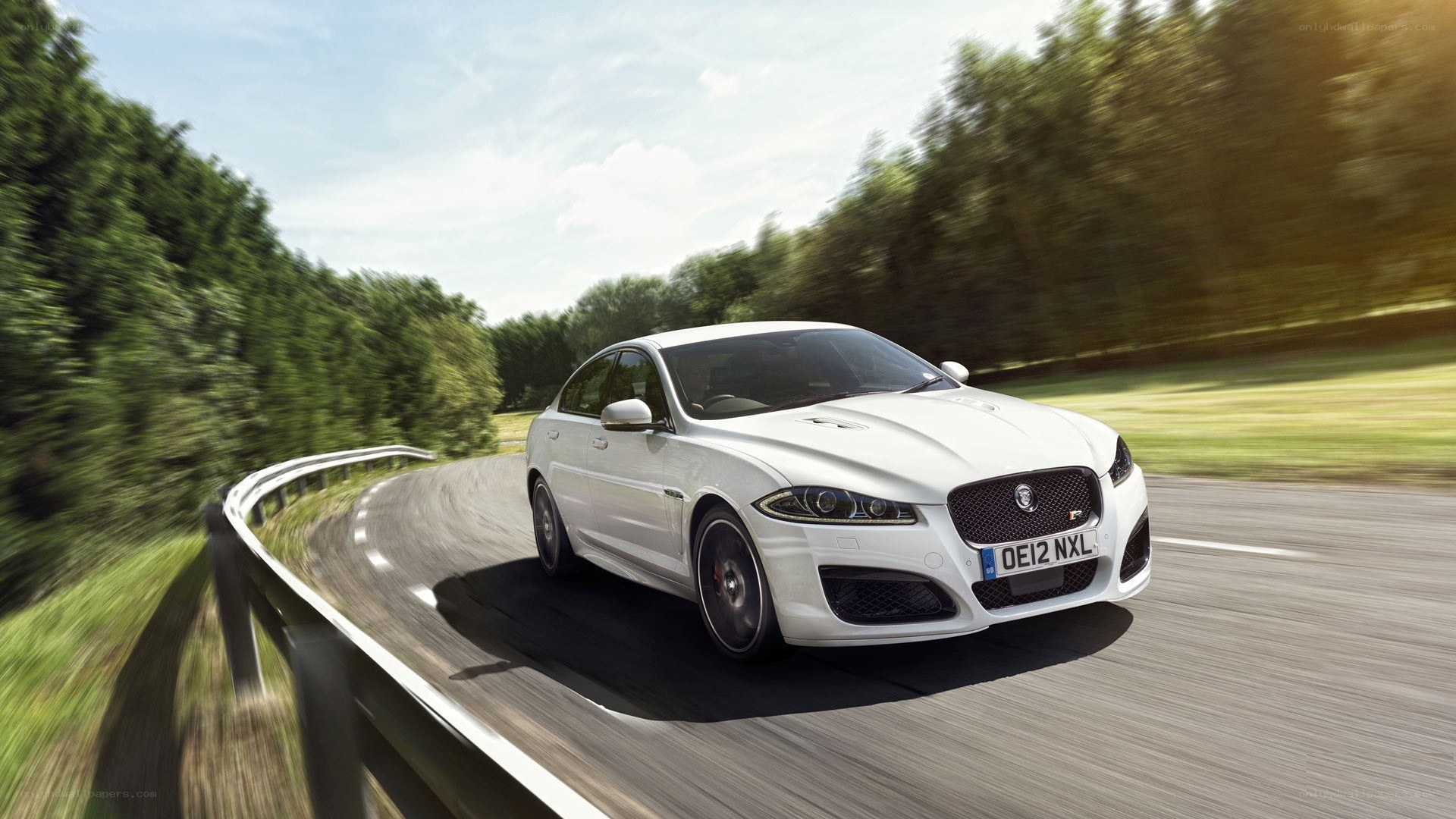 white jaguar driving on road