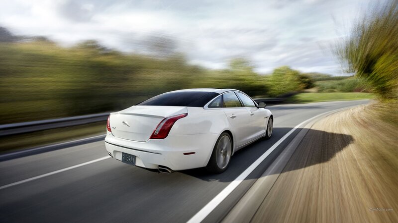 white jaguar driving on road