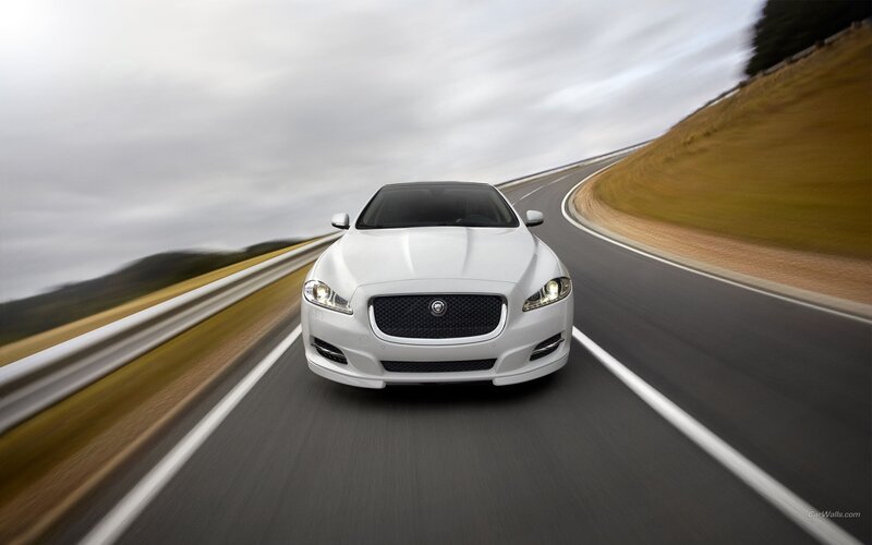 white jaguar driving on road