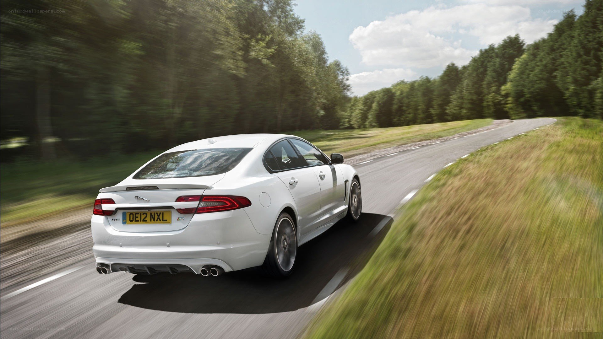 white jaguar driving on road