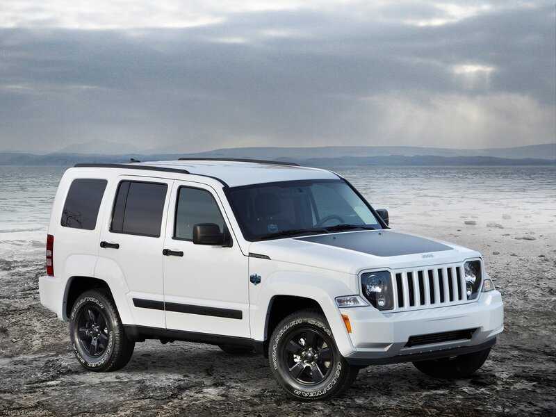white jeep cherokee parked on beach