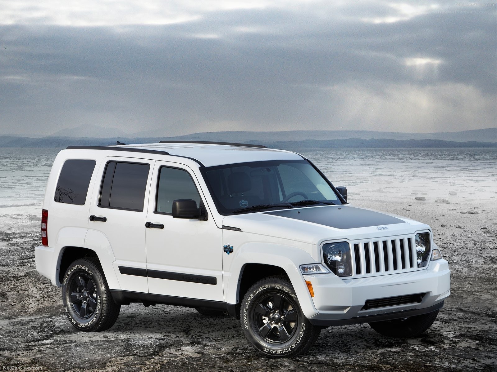 white jeep cherokee parked on beach