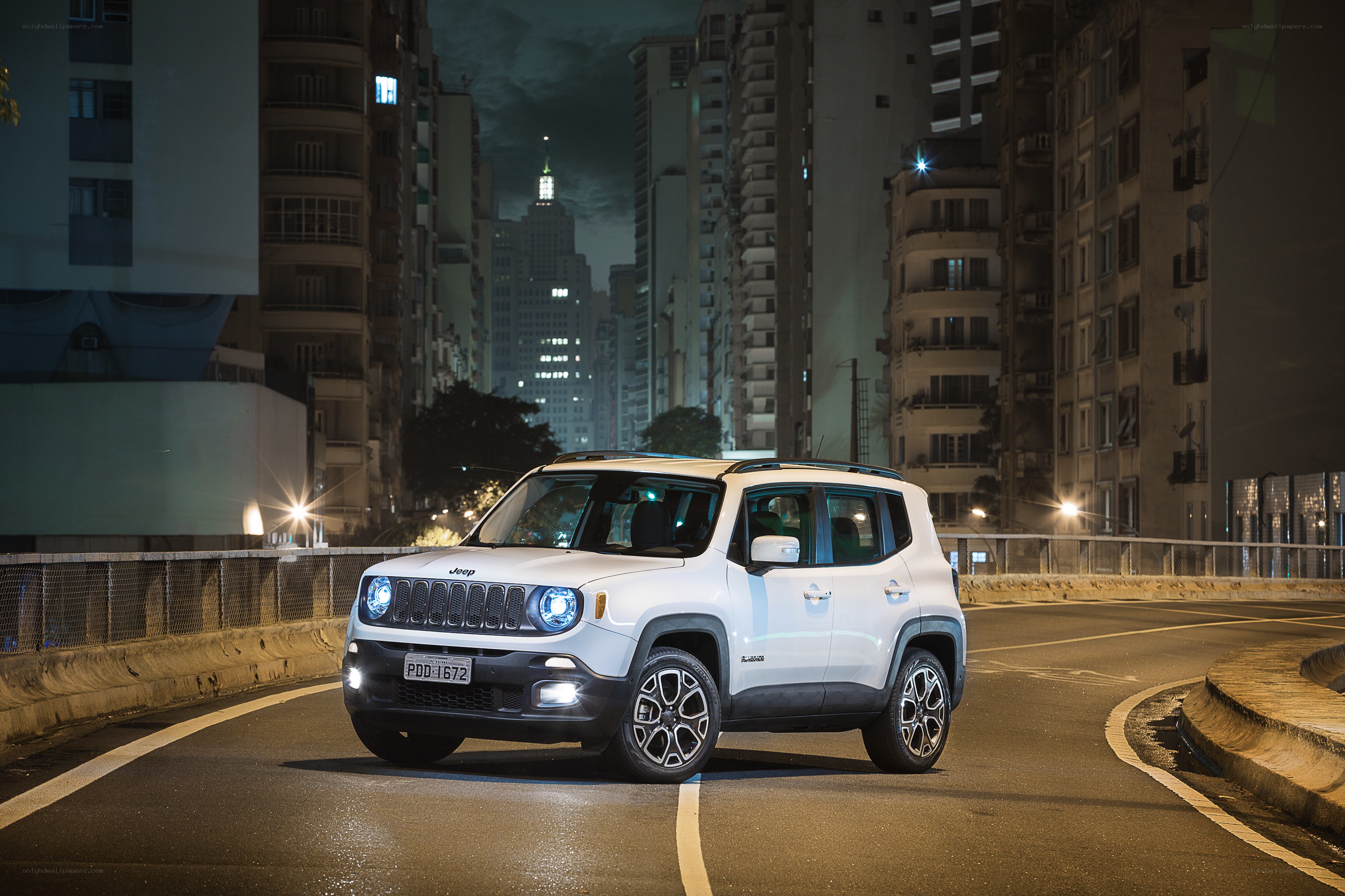 White Jeep on city street at night