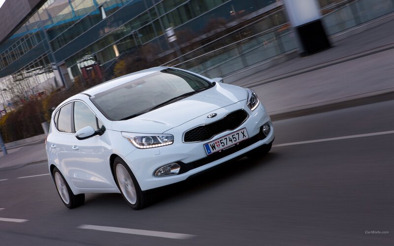 white kia cee'd driving on city street