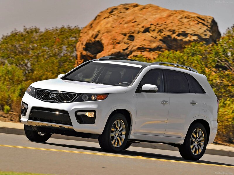 White Kia Sorento driving on road