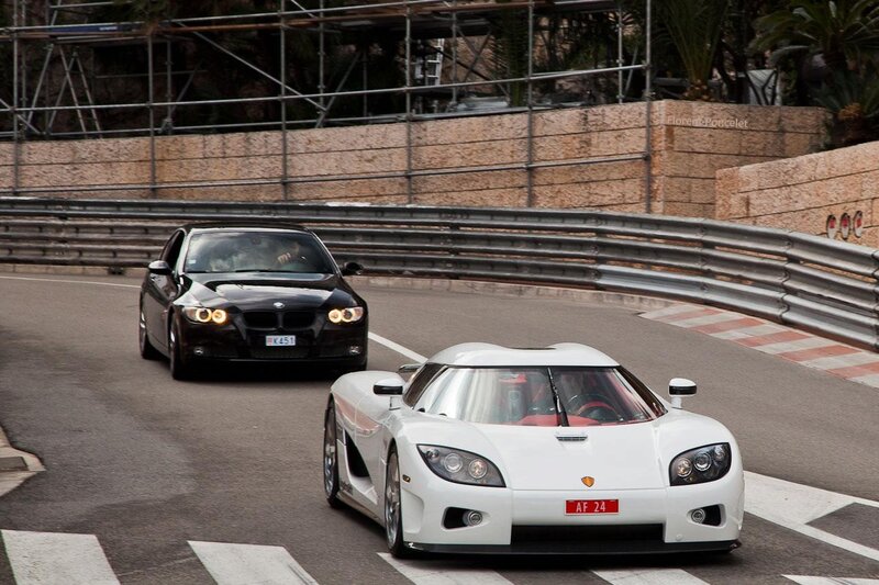 White Koenigsegg and black BMW on track