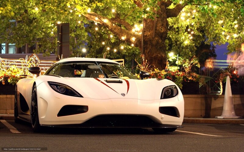 White Koenigsegg in city at night