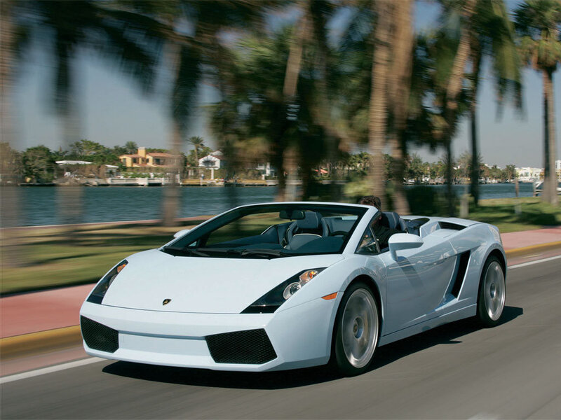 White Lamborghini driving on a coastal road