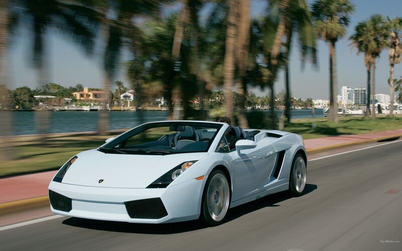 White Lamborghini driving on a coastal road