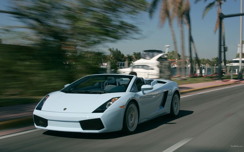 White Lamborghini driving on a coastal road