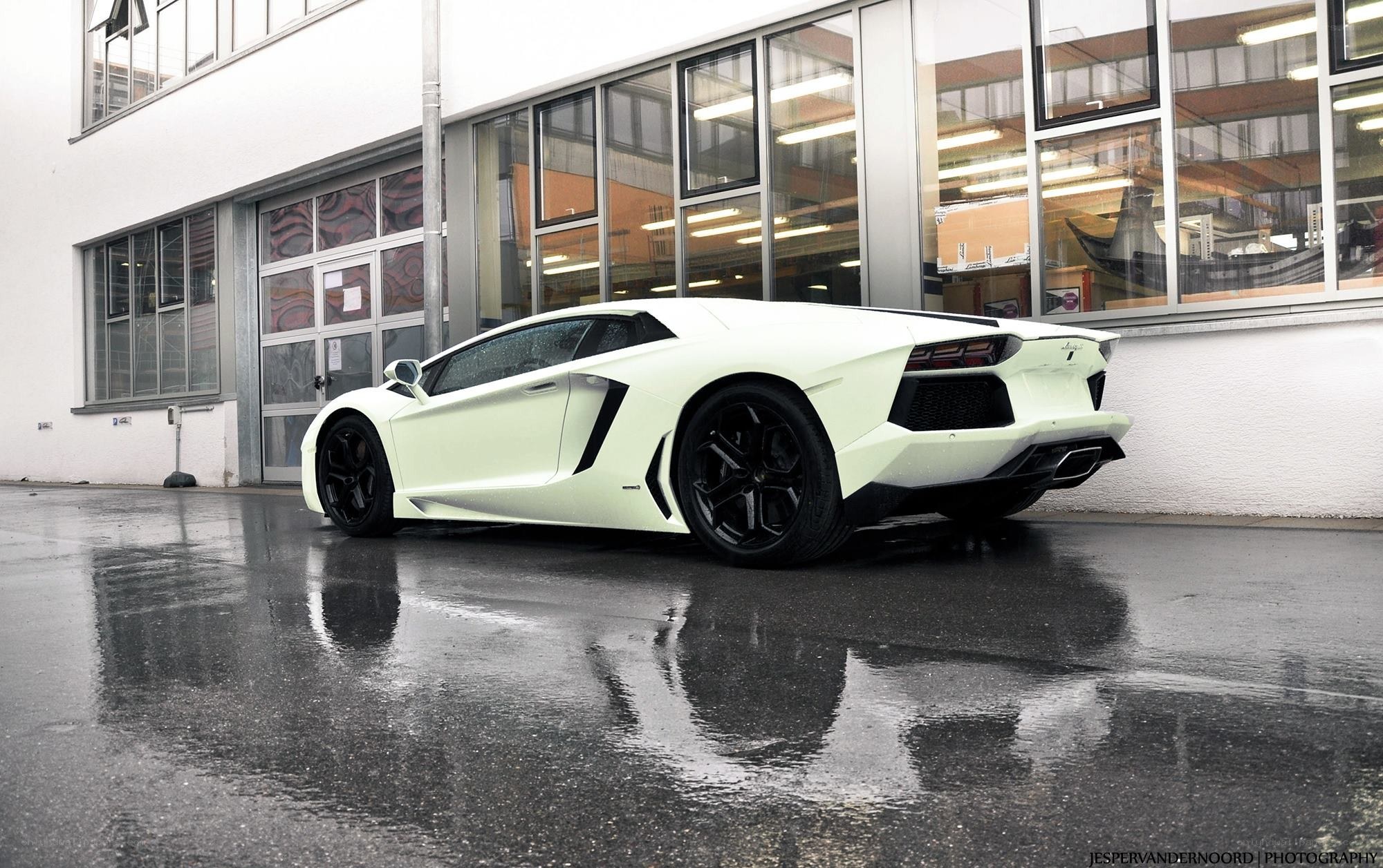 white lamborghini on wet pavement