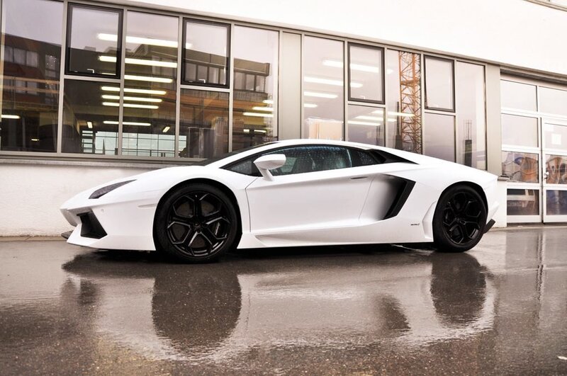 white lamborghini on wet pavement