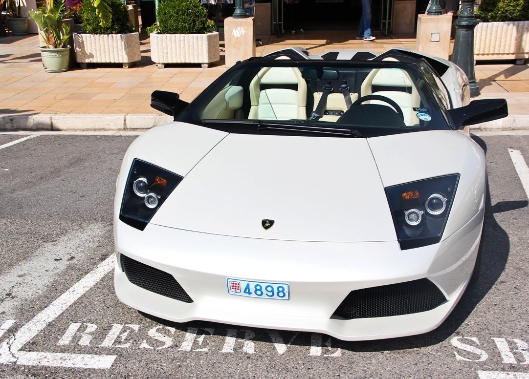 White Lamborghini parked in reserved spot