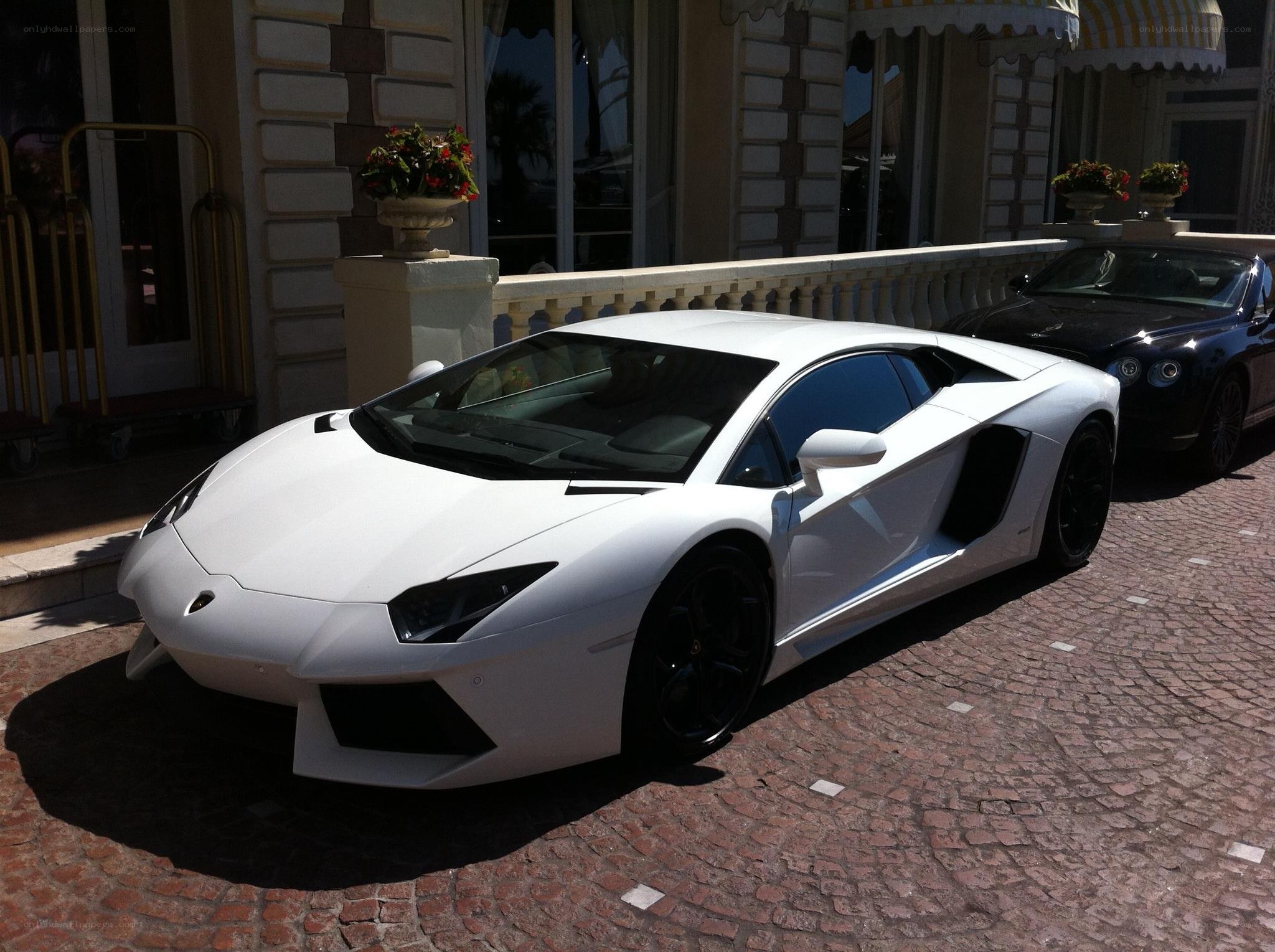 White Lamborghini parked outside hotel