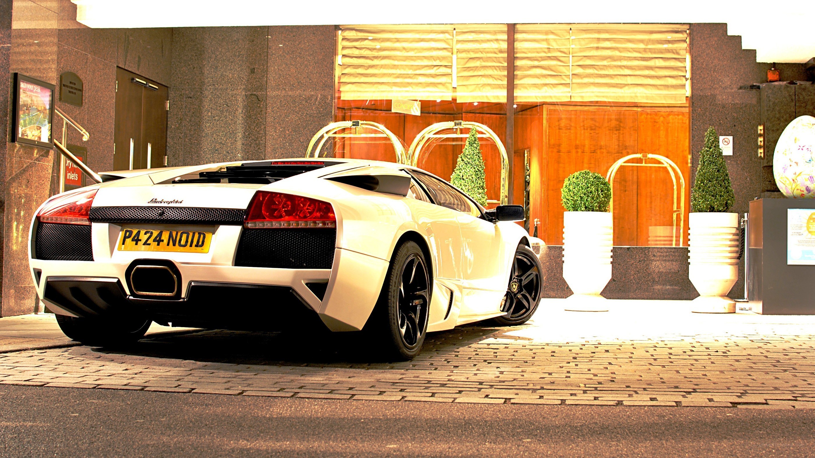 White Lamborghini parked outside hotel