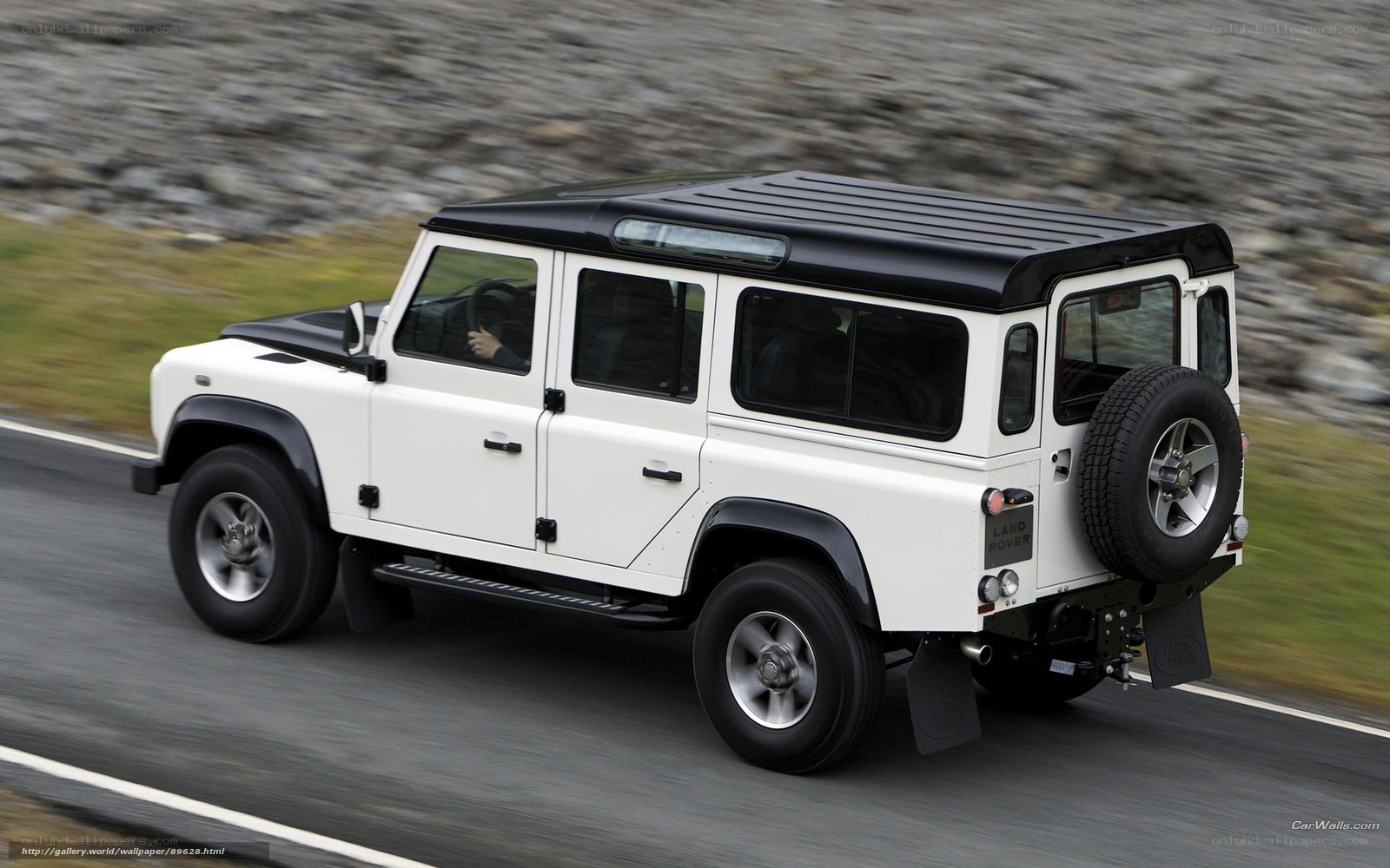white land rover driving on road