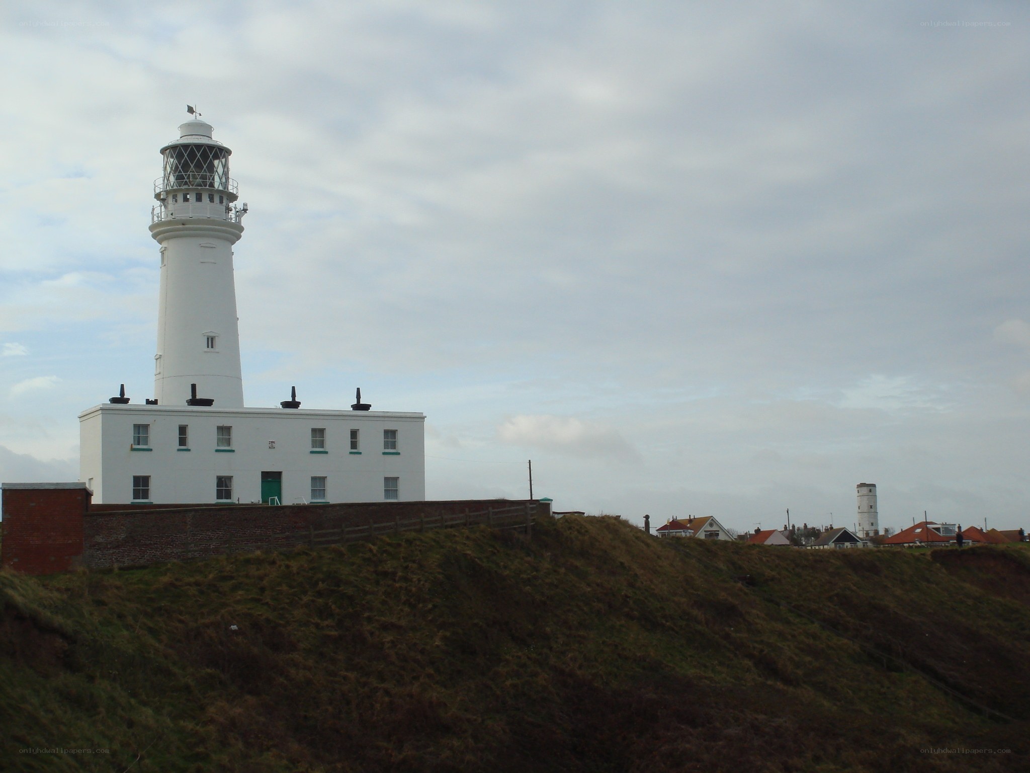 White lighthouse on a grassy cliff