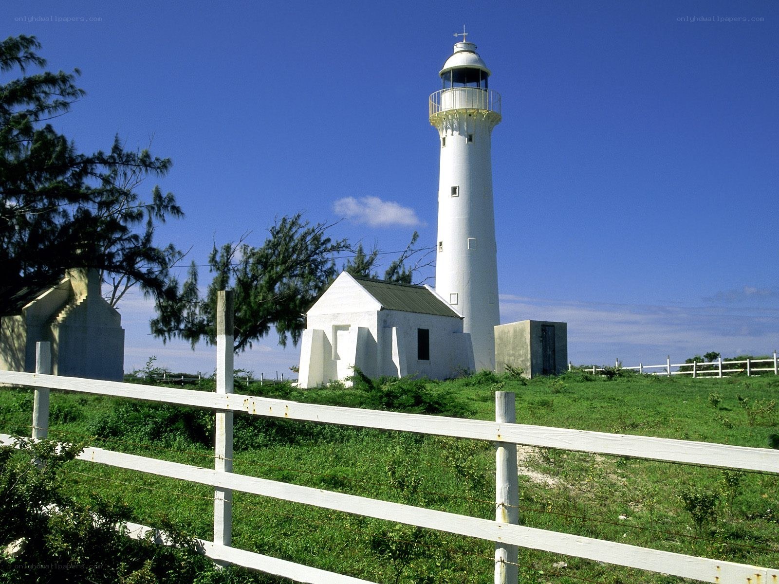 White lighthouse on a green hill