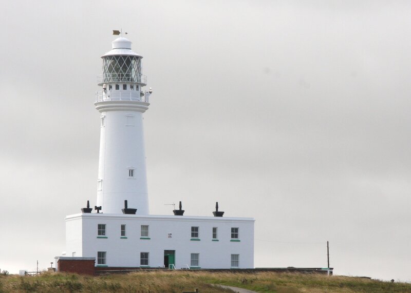 white lighthouse on a hill