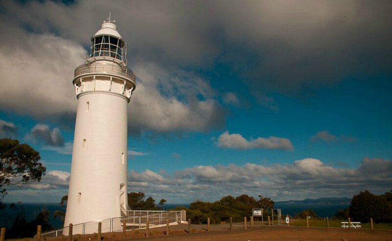 White Lighthouse on Cliff — Blue