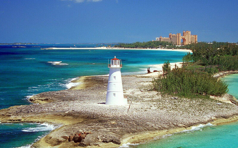 White Lighthouse on Rocky Shore — Blue
