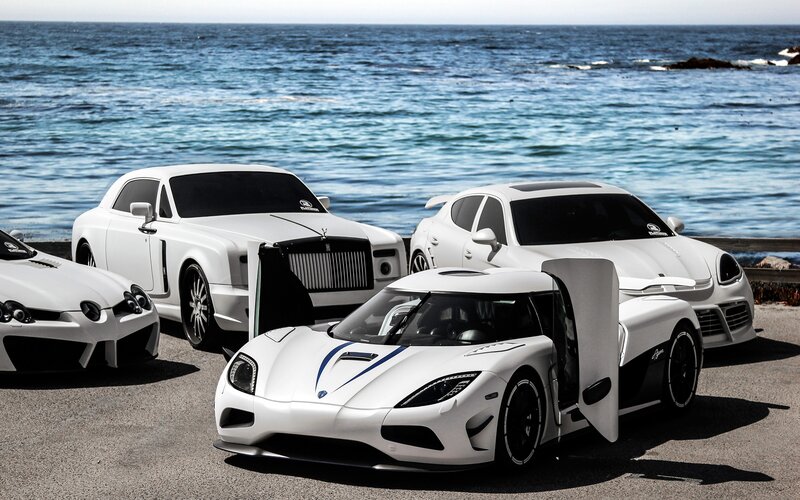 White luxury cars by the ocean