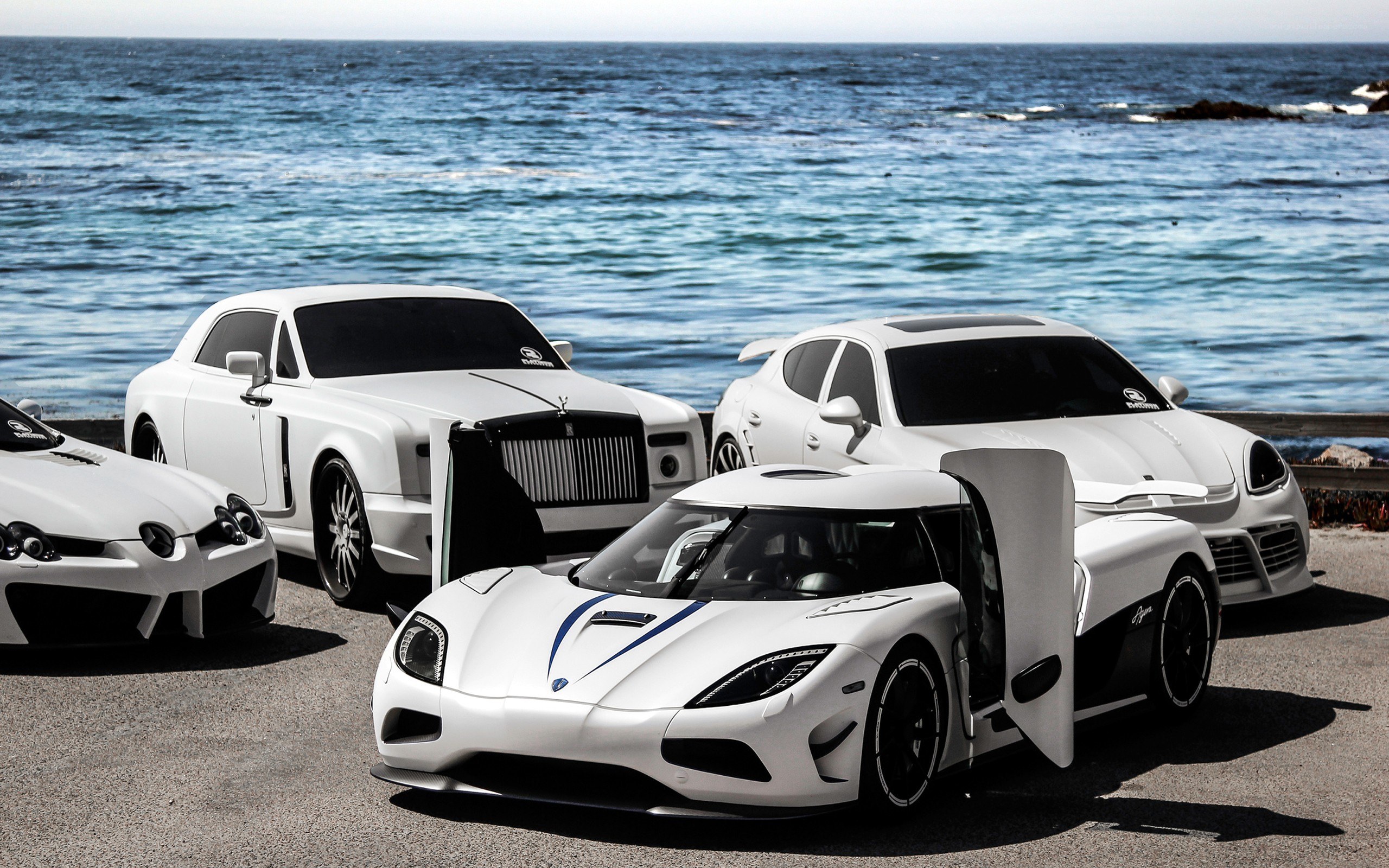 White luxury cars by the sea