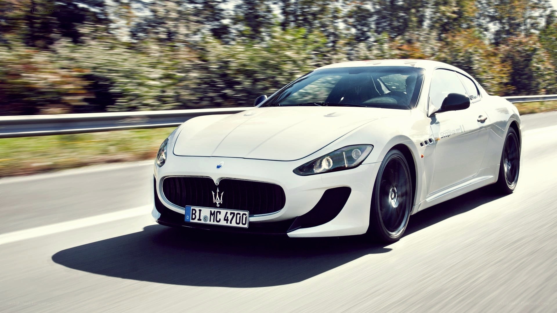 white Maserati driving on road