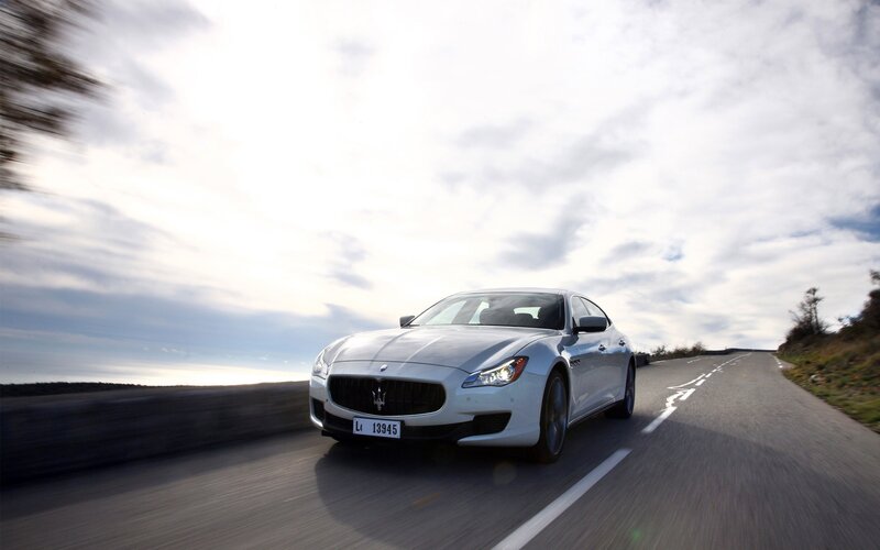 white maserati driving on road