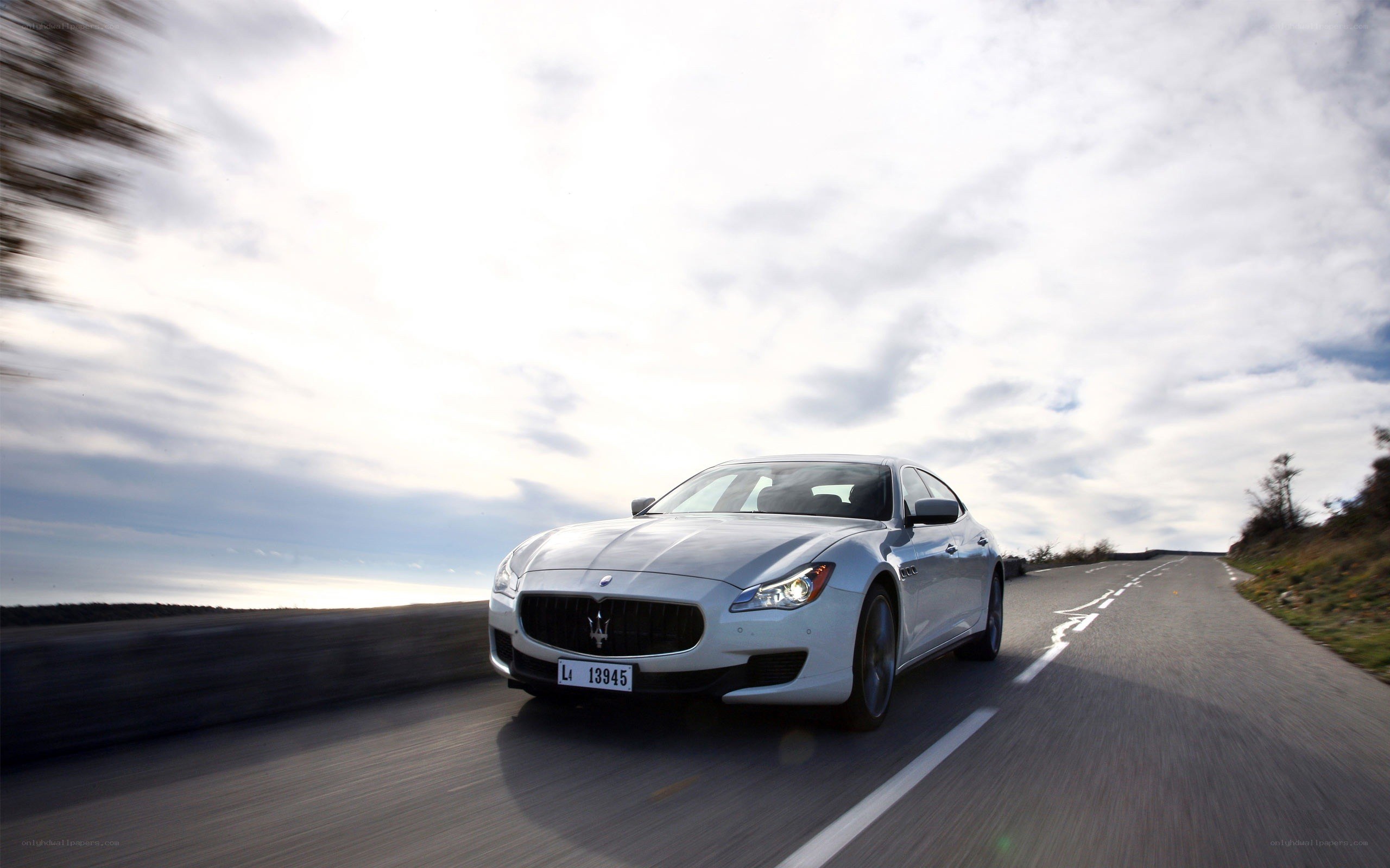 white maserati driving on road