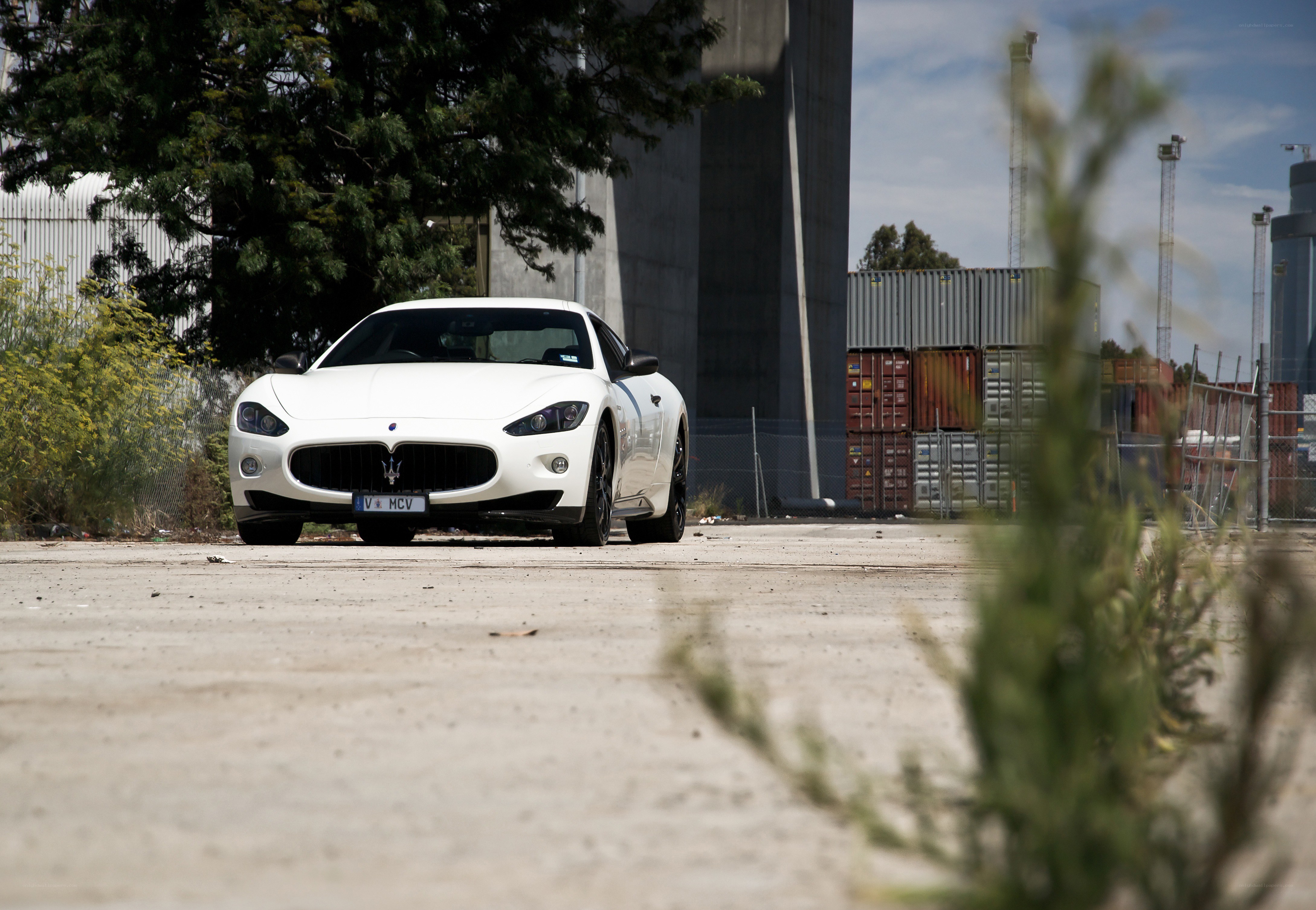 White Maserati in industrial area
