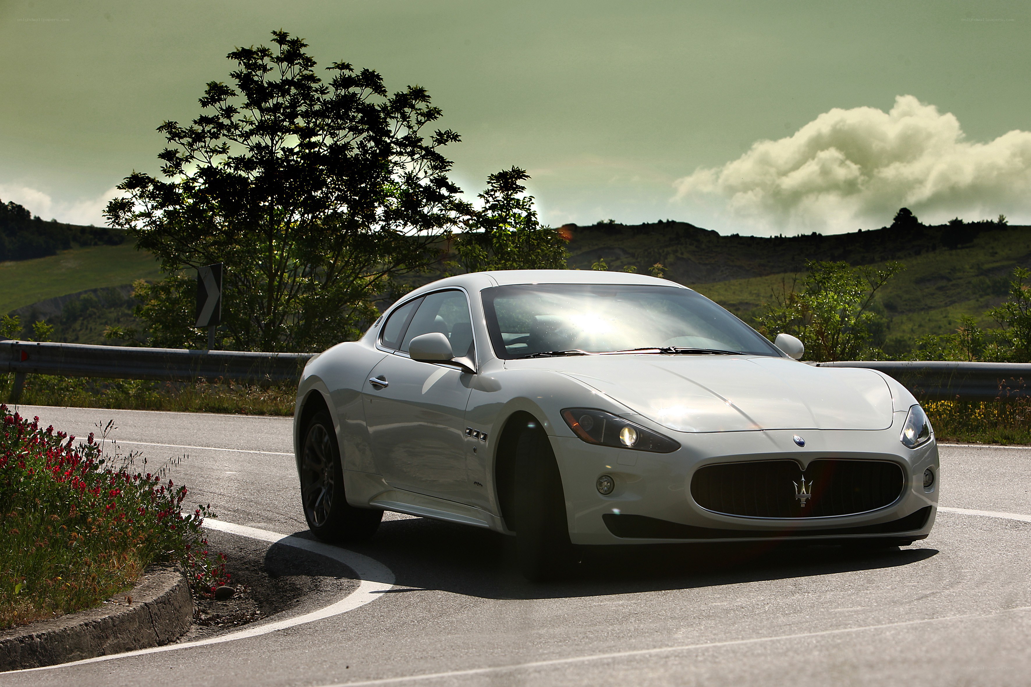 White Maserati on a winding road