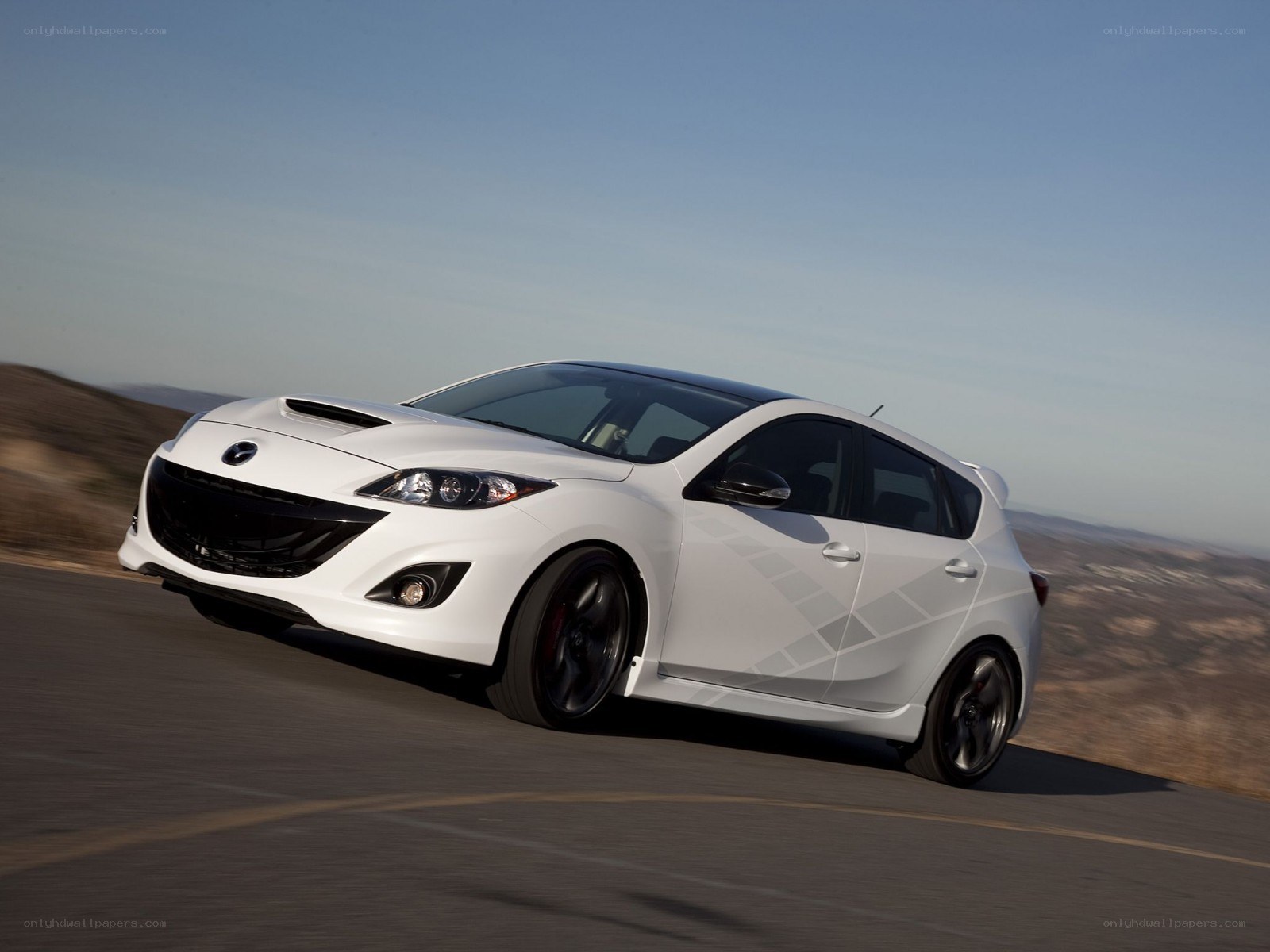 white mazda 3 hatchback on road
