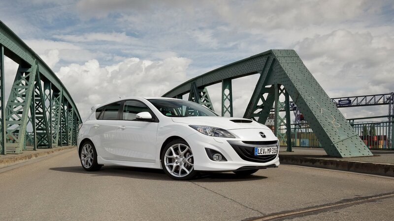 white mazda hatchback on a bridge